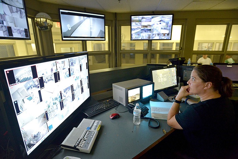 A deputy monitors security camera feeds in the central control room at the Benton County Jail on July 30, 2015, in Bentonvllle.
(File Photo/NWA Democrat-Gazette/BEN GOFF)