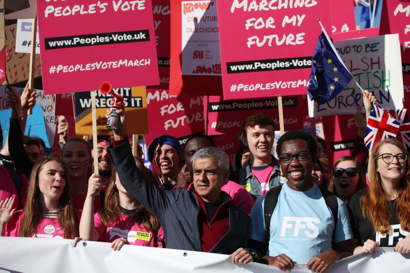 Mayor of London Sadiq Khan, front centre, holds a klaxon horn, as he joins protesters in the People's Vote March for the Future, in London, Saturday Oct. 20, 2018. Some thousands of protesters are marching through central London, Saturday, to demand a new referendum on Britain&#x2019;s Brexit departure from the European Union. (Yui Mok/PA via AP)