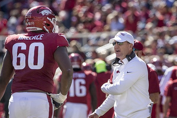 Chad Morris, Arkansas head coach, congratulates right tackle Brian Wallace and as players return to the bench after scoring an extra point in the 3rd quarter vs Tulsa Saturday, Oct. 20, 2018, at Reynolds Razorback Stadium in Fayetteville.