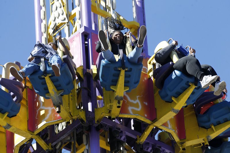 Mahlia Miller (center), 14, screams Sunday as she drops on the Mega Drop ride on the final day of the Arkansas State Fair in Little Rock. 