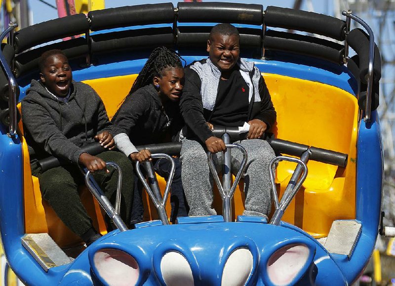 Demetrius Woods (left), 11, reacts while riding the Crazy Mouse ride with his cousins, Jecoria Woods (center), 9, and Corey Woods, 11, during the final day of the Arkansas State Fair on Sunday in Little Rock. 