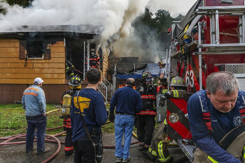 Multiple fire engines respond to a house fire along Virginia Avenue in the Longacre neighborhood of Smithers, W.Va., on Sunday. No injuries were initially reported and the cause of the blaze was unknown.