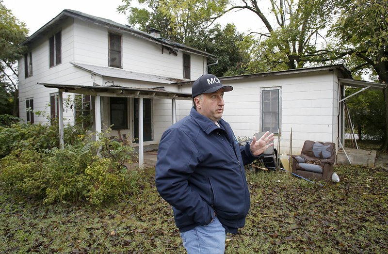 NWA Democrat-Gazette/DAVID GOTTSCHALK Tom Evers, Springdale's chief building inspector, describes Monday, the condition of the structures at 1000 Lowell Road in Springdale. The buildings are scheduled to be razed this week because of their condition.