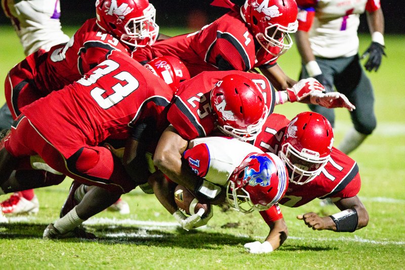 Magnolia’s Shawn Bell (33), Malachi Copeland (43), Robert Mack (4), De’Marco Walker (25) and Jamal McCray (77) takes down a Little Rock McClellan Lion Friday night. The Panthers lost 40-14 to  and will travel to De Queen this week for their final road game of the season.