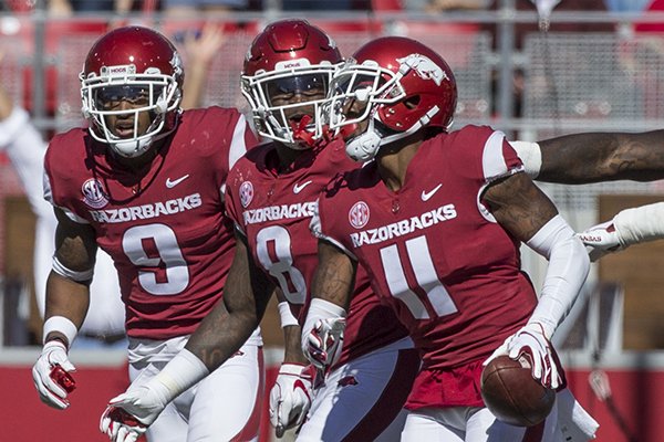 Santos Ramirez (from left), De'Jon Harris and Ryan Pulley, celebrate after Pulley made an interception in the second quarter of a game against Tulsa on Saturday, Oct. 20, 2018, at Reynolds Razorback Stadium in Fayetteville.