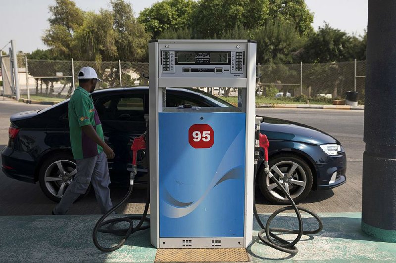 An attendant refuels a car earlier this month at a gas station in Dhahran, Saudi Arabia. The Saudi energy minister said Monday that the country would not use its oil policy for political gain. 
