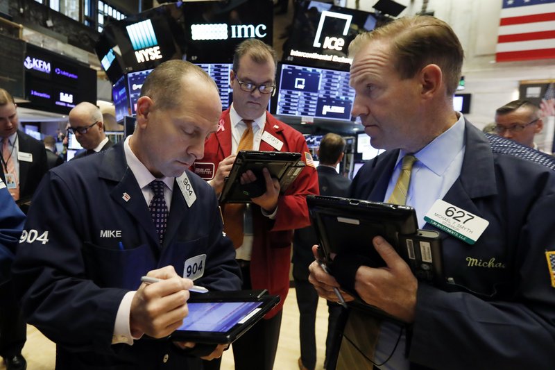 Traders Michael Urkonis, left, William Lawrence, center, and Michael Smyth work on the floor of the New York Stock Exchange, Monday, Oct. 22, 2018. U.S. stocks veered broadly lower in early trading Monday as losses in health care companies and banks outweighed gains elsewhere. (AP Photo/Richard Drew)