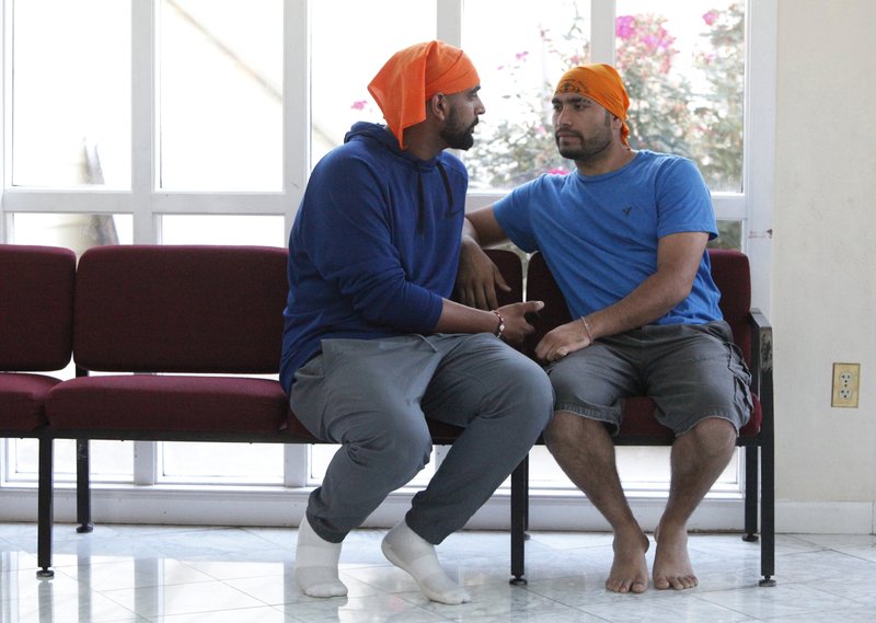 In this Oct. 3, 2018 photo, Satyawart, left, and Balvinder Singh, immigrants from India freed from the federal prison in Sheridan, Ore., talk at the Dasmesh Darbar Sikh temple in Salem, Ore. After Trump's zero-tolerance policy recently sent immigrant detainees to a federal prison in rural Oregon, more than 100 lawyers, retirees, recent college graduates, clergy and others in the area stepped up to help out. (AP Photo/Amanda Loman)