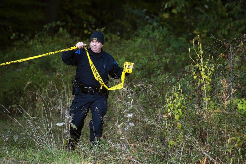 In this Monday, Oct. 22, 2018 photo, detectives investigate the scene where remains believed to be those of a southwestern Michigan woman who disappeared in 2010 were found, in Fulton, Mich. Doug Stewart, who was convicted of killing his estranged wife in 2011, took police to the burial site Monday. (Daniel Vasta /Kalamazoo Gazette via AP)

