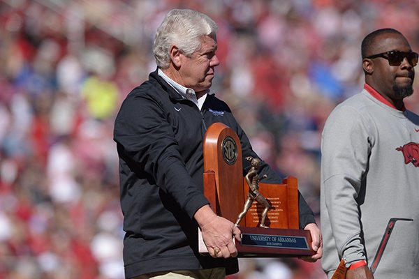 Arkansas coach Lance Harter holds an SEC championship trophy during an on-field recognition at the Razorbacks' football game against Tulsa on Saturday, Oct. 20, 2018, in Fayetteville. 