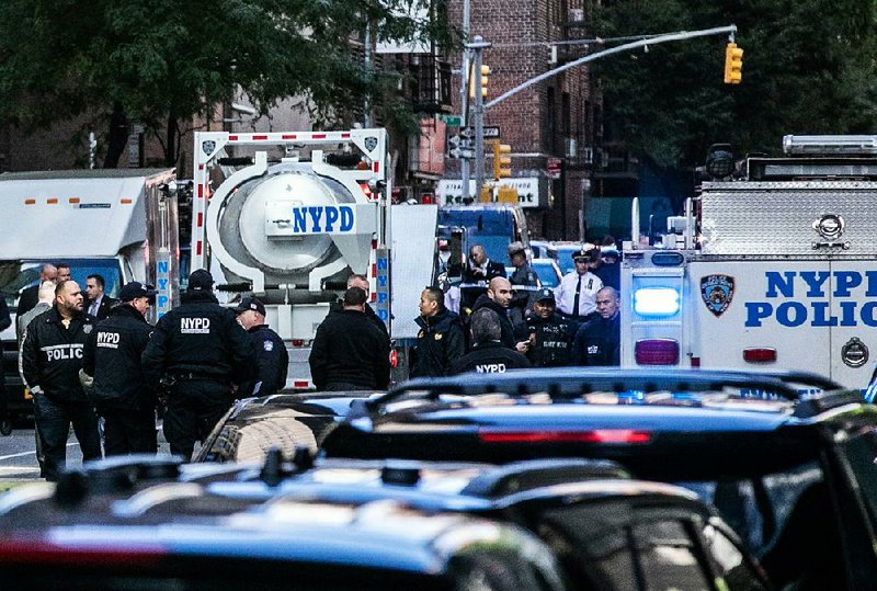 Police investigators gather near a bomb-squad truck Wednesday outside the Time Warner Center in New York, where an explosive device was discovered at the offices of CNN.