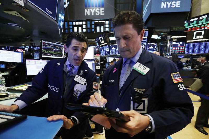 Specialist Peter Mazza (left) and trader Anthony Carannante work Wednesday on the floor of the New York Stock Exchange as stock prices fall.