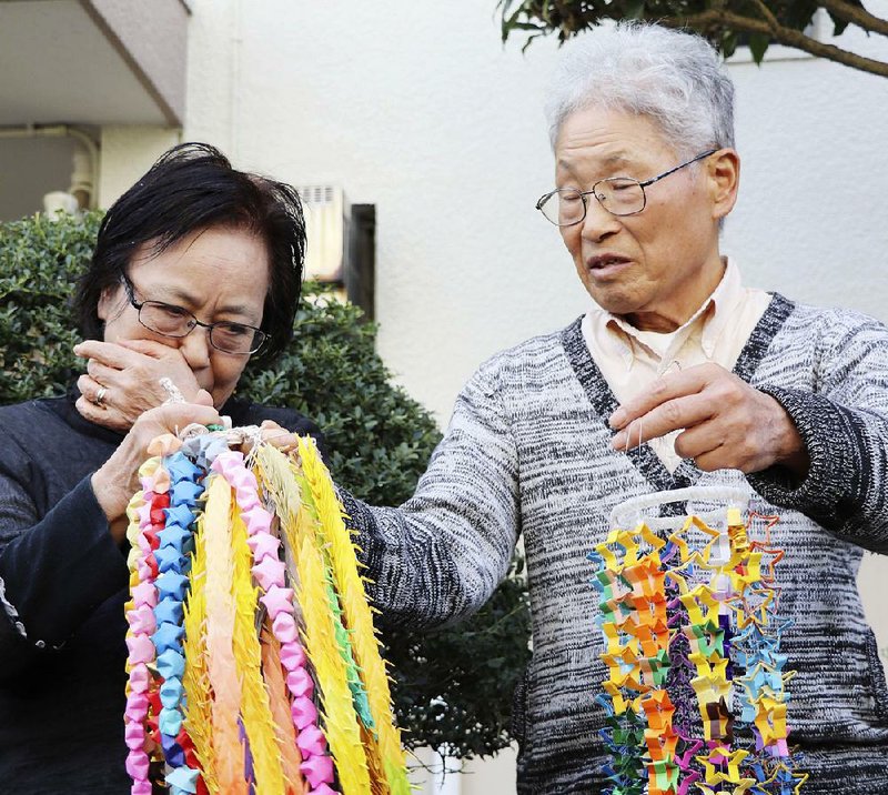 Sachiko Yasuda and husband Hideaki Yasuda celebrate Wednesday outside their home in Iruma, Japan, after learning that their son, freelance journalist Jumpei Yasuda, was safe.