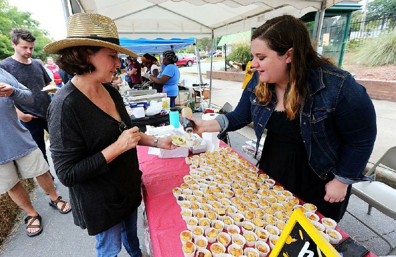 Melanie Keen (right) squirts maple syrup on a cornbread sample  for Kelley Cooper at the 2017 Arkansas Cornbread Festival. This year’s festival on Saturday will feature not only a wide range of cornbreads, but also music, art and family fun. 