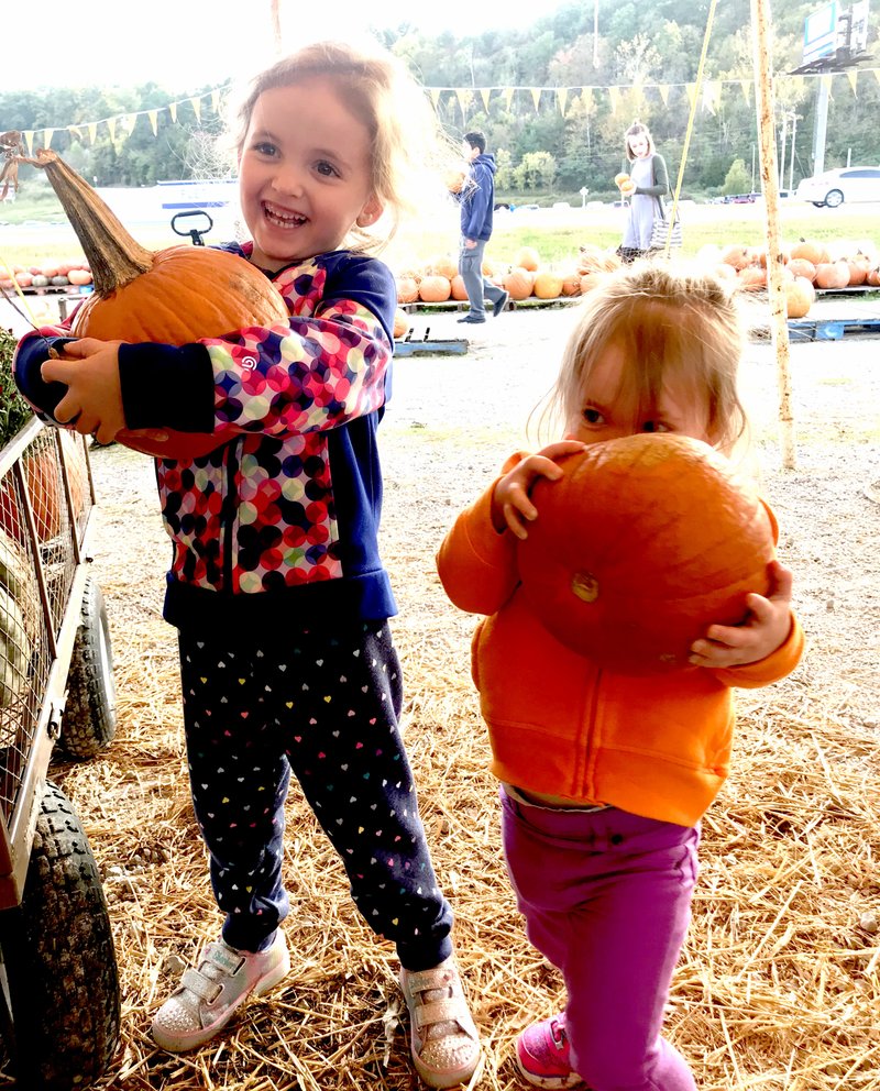 Sally Carroll/McDonald County Press Leiona Pierce, 4, and her sister, Luella, 2, show off the pumpkins they picked at the pumpkin patch near the Missouri/Arkansas stateline.