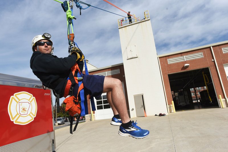NWA Democrat-Gazette/FLIP PUTTHOFF 
Randy Fine, firefighter with the Bentonville Fire Department, gets hoisted skyward Wednesday Oct. 24 2018 during a ropes training class at the Bentonville fire station. Firefighters from Bentonville, Little Rock and Jacksonville fire departments trained in rescue techniques using ropes, pulleys and other tools, said instructor Nathan Keck, a captain with the Rogers Fire Department.