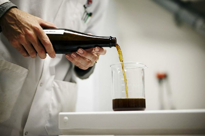 A lab technician pours a bottle of beer brewed using cannabis into a beaker at the Province Brands of Canada laboratory in Belleville, Ontario, Canada, in August. 