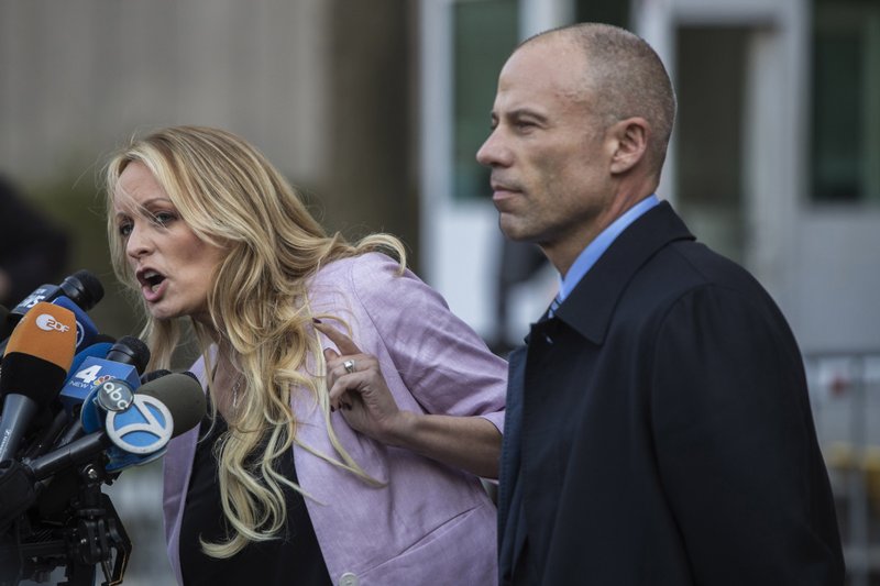 Attorney Michael Avenatti, right, listens outside Federal Court in New York as his client Stormy Daniels addresses the media on April 16, 2018. MUST CREDIT: Bloomberg photo by Victor J. Blue.