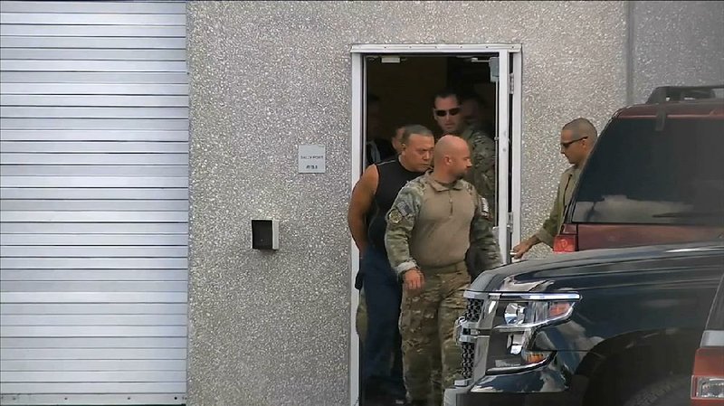 FBI agents escort mail-bomb suspect Cesar Sayoc (in sleeveless shirt) in Miramar, Fla., after his arrest.