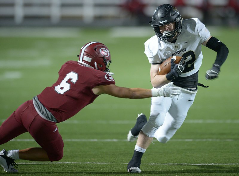 NWA Democrat-Gazette/ANDY SHUPE Bentonville running back Cole Joyce (right) carries the ball as Springdale safety Ricky Montufar (6) reaches to make the stop Friday, Oct. 26, 2018, during the first half of play at Jarrell Williams Bulldog Stadium in Springdale. Visit nwadg.com/photos to see more photographs from the game.