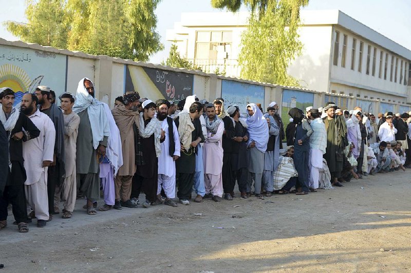 Men line up to enter a polling station in Kandahar, Afghanistan, on Saturday as their province holds parliamentary elections that were delayed by violence. 