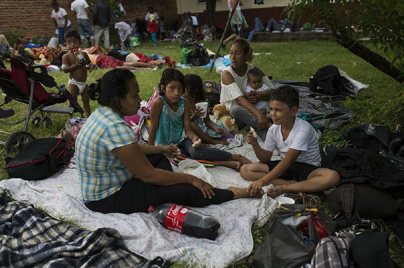 Migrants who are part of a caravan of Central Americans trying to reach the U.S. border eat breakfast Sunday in Tapanatepec, Mexico.