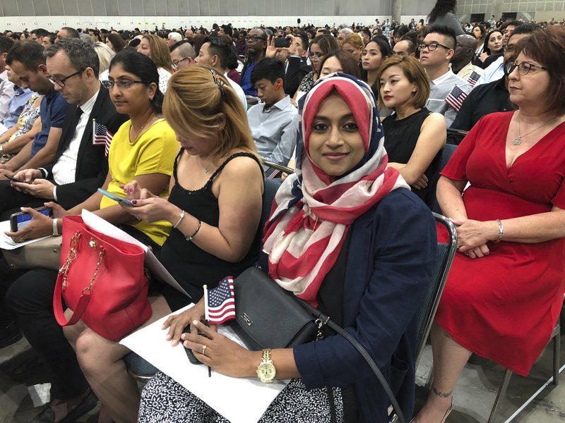 In this Sept. 18, 2018 photo Sameeha Alkamalee Jabbar, a 38-year-old from Orange County sits during a naturalization ceremony in Los Angeles. Alkamalee Jabbar who is originally from Sri Lanka, said the process took ten months and at times she worried but knew about the backlog. More than 700,000 immigrants are waiting on their applications to become U.S. citizens, a process that in many parts of the country now takes a year or more. (AP Photo/Amy Taxin)