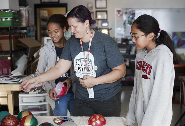 NWA Democrat-Gazette/CHARLIE KAIJO Art teacher Nikki Kalcevic (center) helps sixth-grader Shaekyra Carter, 11, (left) paint her ornament with Christina Espinosa, 11, (right) during an art class Monday at Ardis Ann Middle School in Bentonville.