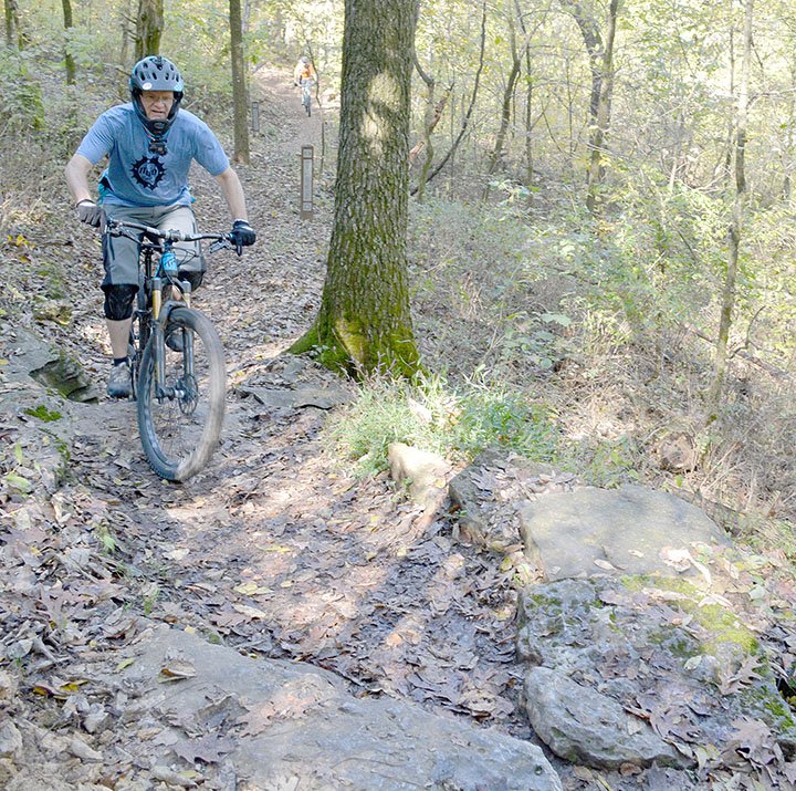 Keith Bryant/The Weekly Vista Charles Williams climbs up a slick, steep rock before going into a short rock garden at Blowing Springs for last Saturday's IMBA Dirty 30, a group ride that overlapped with last weekend's Outerbike event.