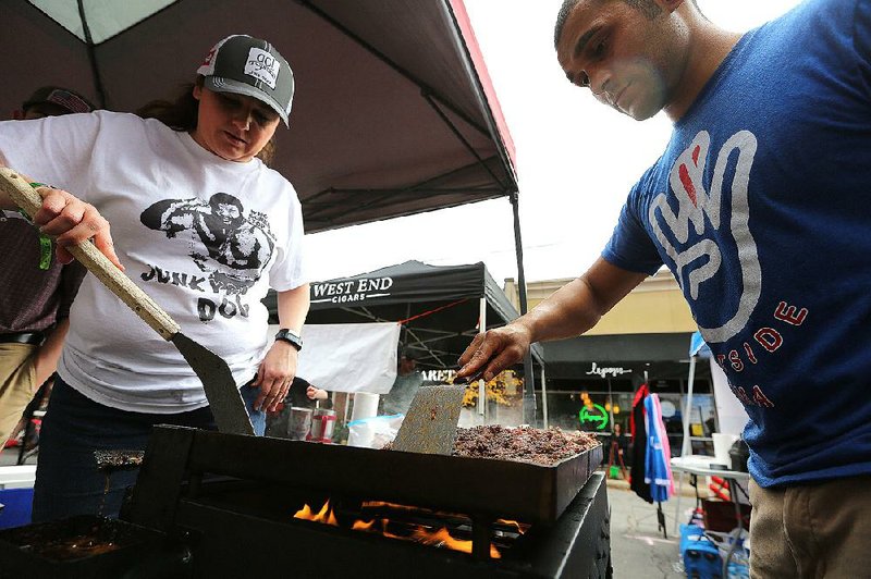 Regina Davis (left) and Jeremiah Cullum cook ground beef for their chili during last year’s Chili Fights in the Heights. This year’s event is Saturday, just one entertainment option for people in town for the Komen Race for the Cure. 