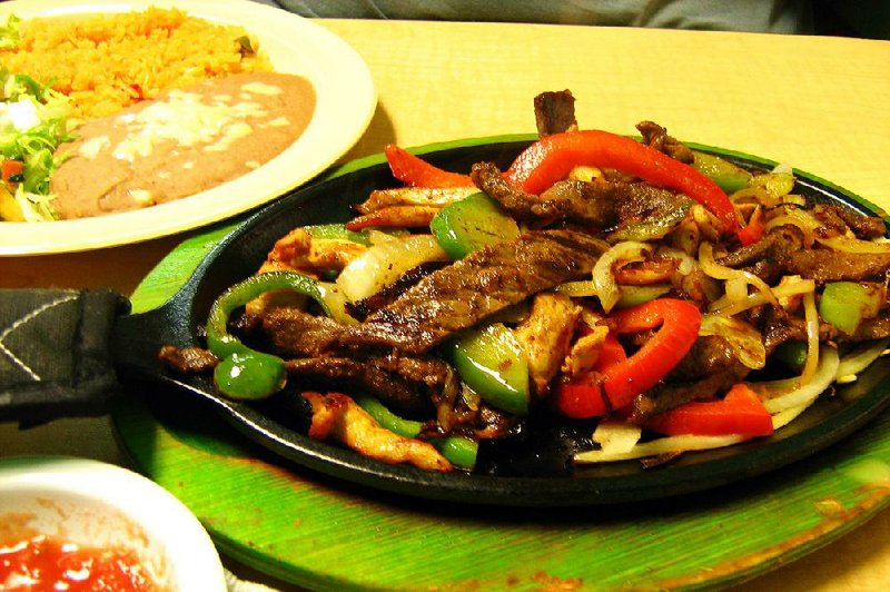 Taqueria Amigos Mexican Restaurant in Jacksonville offers fajitas made with grilled strips of steak and chicken, peppers and onions. They are served with rice, beans and tortillas. 