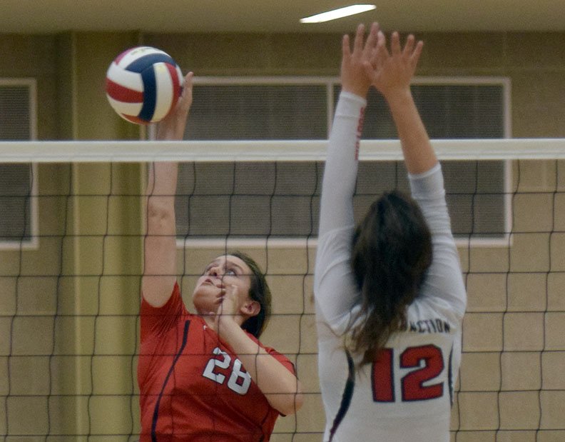 RICK PECK/SPECIAL TO MCDONALD COUNTY McDonald County's Emily Landers (28) hits a spike away from Carl Junction blocker Jessa Hylton (12) during the Lady Mustangs' 25-13, 25-8, loss in the first round of the Missouri Class 4, District 11, Volleyball Tournament held on Oct. 23 at Joplin High School.