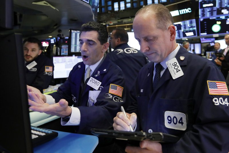 In this Oct. 23, 2018, file photo specialist Peter Mazza, center, and trader Michael Urkonis work on the floor of the New York Stock Exchange.  (AP Photo/Richard Drew)