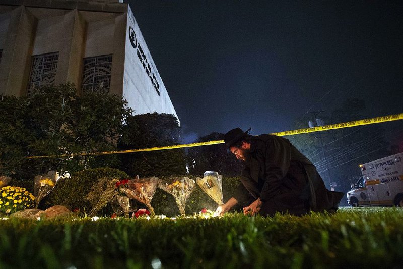 Rabbi Eli Wilansky lights a candle after a mass shooting at Tree of Life synagogue in Pittsburgh’s Squirrel Hill neighborhood. Robert Bowers, the suspect in the Oct. 27 mass shooting, expressed hatred of Jews during the rampage and told officers afterward that Jews were committing genocide and he wanted them all to die, according to charging documents made public Sunday.