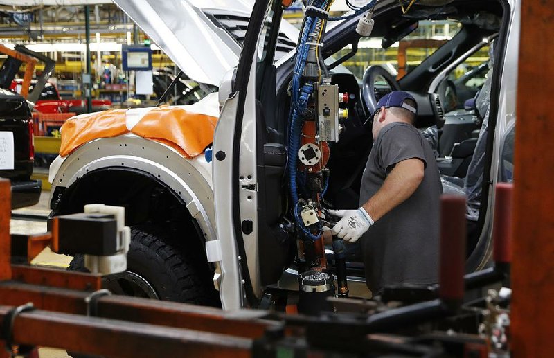 An autoworker installs front doors on a 2018 Ford F-150 pickup in September at an assembly plant in Dearborn, Mich. American factory output growth slowed last month. 