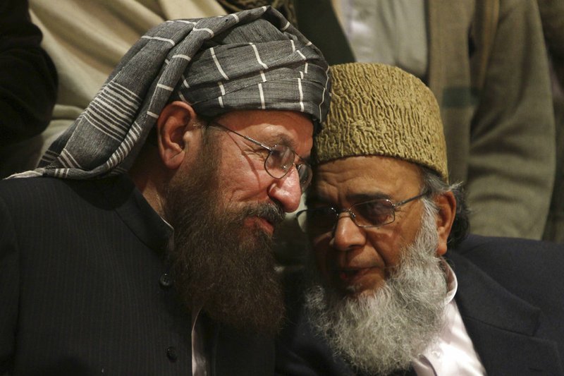 In this Feb.15, 2014, file photo, Pakistani religious cleric Samiul Haq, left, talks with Syed Munawar Hasan, the head of the Jamaat-e-Islami party, during a press conference in Lahore, Pakistan. Pakistani police and family of a top cleric Haq who was known as "father of the Taliban" has been killed in a knife attack in his bedroom at home in the garrison city of Rawalpindi. Haq's son Hamidul Haq says his father was killed Friday, Nov. 2, 2018.(AP Photo/K.M. Chaudary, File)