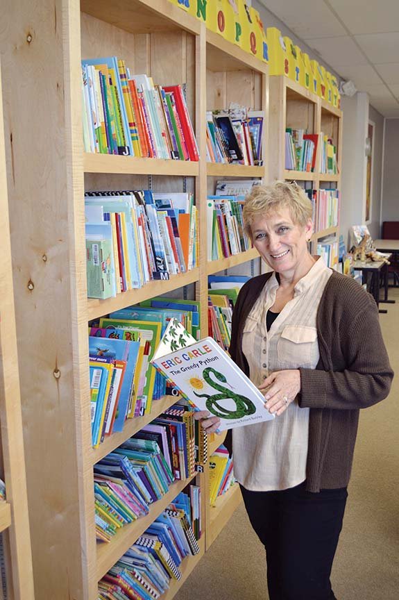 Carol Crockett, manager of the Conway satellite office of Child Care Aware of Northcentral Arkansas, holds one of the many books available for child care centers and preschools to check out. The resource center and library in Olympia Plaza, 2115 E. Oak St., Suite 3, in Conway, was created to assist licensed preschool and child care providers with books, curricula, lesson plans, manipulatives for fine-motor skills and other resources for free, as well as to provide professional development.