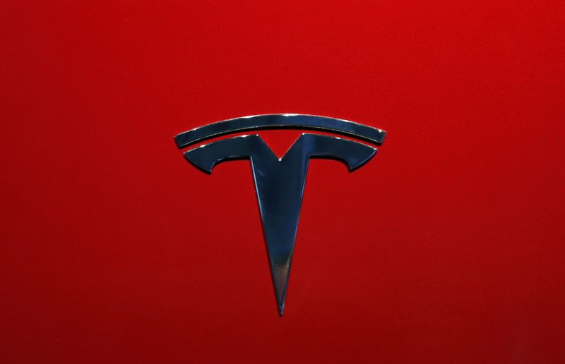 FILE- This Oct. 3, 2018, file photo shows the logo of Tesla Model 3 at the Auto show in Paris. U.S. securities investigators have subpoenaed information from Tesla about production forecasts for the Model 3 electric car that were made last year, the company acknowledged in a regulatory filing Friday, Nov. 2. The disclosure in Tesla&#x2019;s quarterly financial report also says the Securities and Exchange Commission subpoena covered other public statements made about Model 3 production. The filing also says Tesla is cooperating with a Justice Department request for information about production. (AP Photo/Christophe Ena, File)