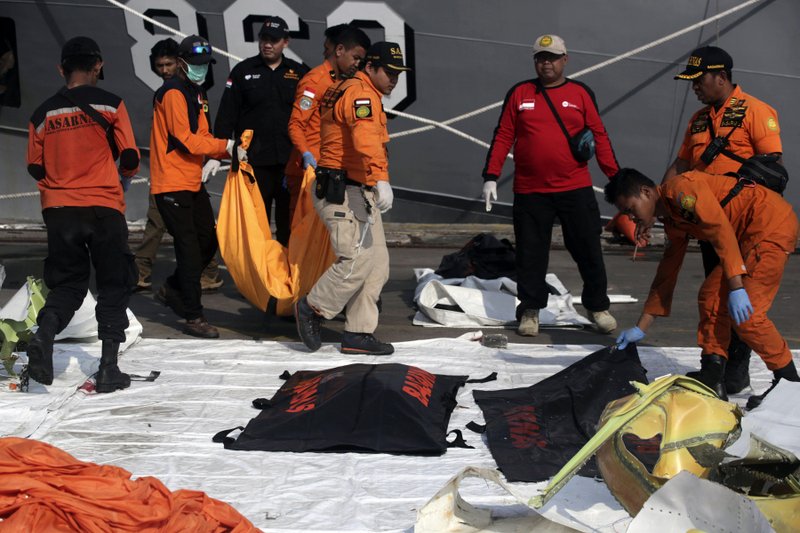 Rescuers carry body bags containing the remains of the victims of Lion Air crash at Tanjung Priok Port in Jakarta, Indonesia, Friday, Nov. 2, 2018. New details about the crashed aircraft previous flight have cast more doubt on the Indonesian airline's claim to have fixed technical problems as hundreds of personnel searched the sea a fifth day Friday for victims and the plane's fuselage. (AP Photo/Binsar Bakkara)