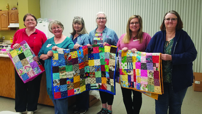 Quilters: Sharon Johnson, Terrie Simpson, Betsy Welch, Trisha Nash, Lauren McGarrh (EHC Advisor) and Judy Couch hold up a quilt that was completed. The ladies are members of the Union County EHC.