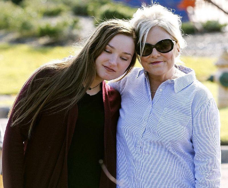 Laurie Jernigan (right), mother of Ebby Steppach, gets a hug from Danielle Westbrook, Steppach’s best friend, during a ceremony Sunday at Chalamont Park in Little Rock.