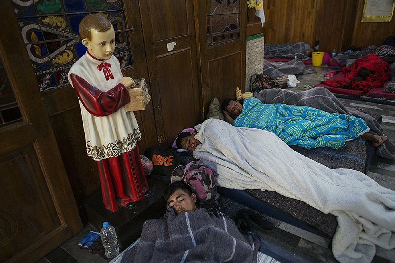 Central American migrants sleep early Sunday inside a church in Puebla, Mexico, that opened its doors to them. Members of the group splintered off from the main caravan to reach the capital faster. 