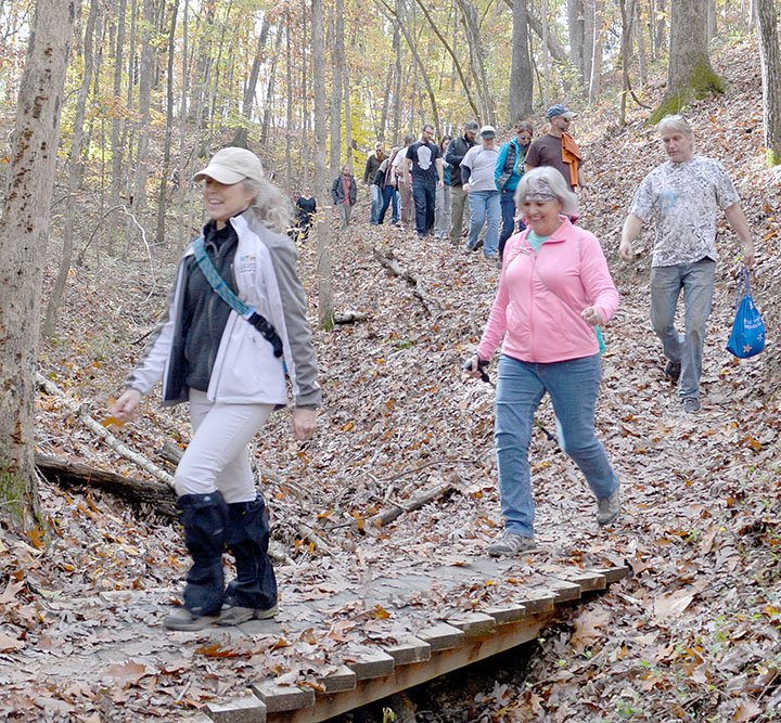 Keith Bryant/The Weekly Vista Bella Vista trails coordinator Kay Curry leads a group of hikers into the Back 40 trails for a mushroom picking group hike.