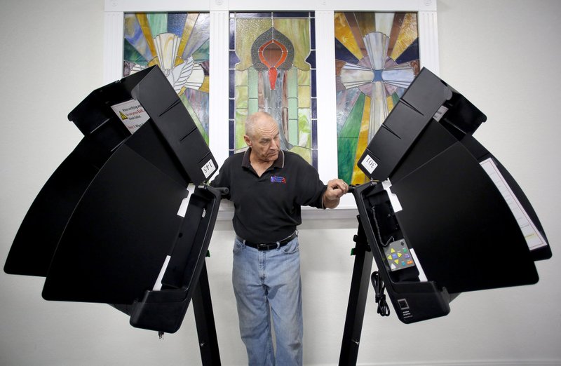 Joe Batlle, Washington County Election Official Supervisor, adjusts the location of ballot marking device kiosks Monday at the Main Street Baptist Voting Center in Farmington. 