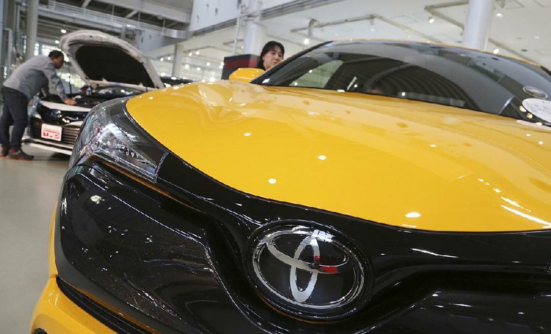 People look at the cars in a Toyota showroom in Tokyo last year. Sales fell in Japan and the U.S. in the automaker’s most recent quarter, but the company saw gains in other parts of the world.