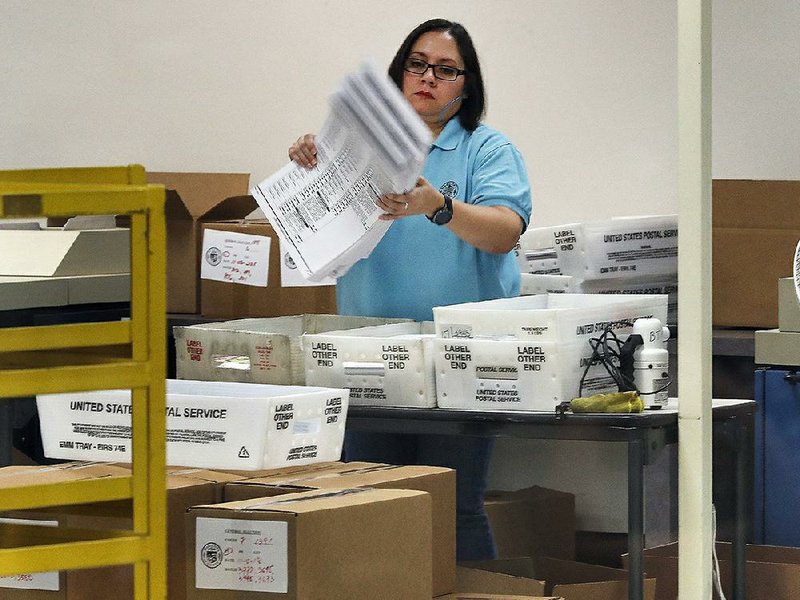 An official prepares ballots at an election center Tuesday in Phoenix. A building used as a Phoenix polling site was foreclosed on Monday night and its doors locked, surprising officials. 