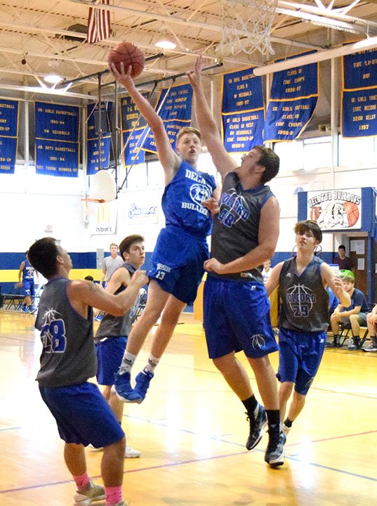 Westside Eagle Observer/MIKE ECKELS Decatur's Ryan Ross works his way through a hive of Hornets to put up a hook shot during the Decatur-Colcord Summer League basketball game at Peterson Gym in Decatur May 30. Decatur begins its 2018-19 season when it travels to St. Paul Nov. 9.