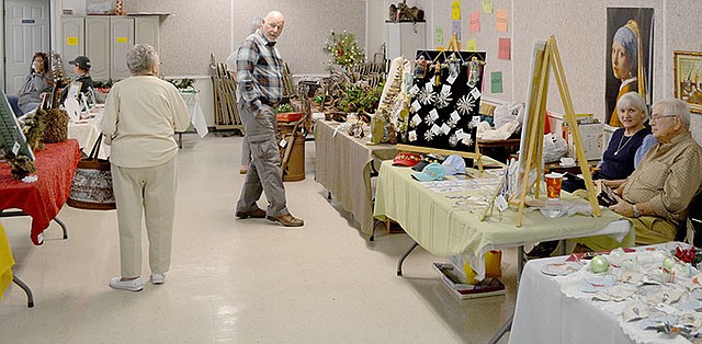 Keith Bryant/The Weekly Vista Shoppers look at the arts and crafts on display at the Wishing Spring Gallery Christmas Bazaar.