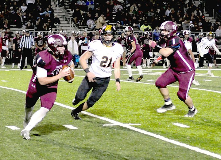 MARK HUMPHREY ENTERPRISE-LEADER Lincoln senior quarterback Caleb Lloyd, chased out of the pocket by Prairie Grove defensive end James Millwood, scrambled for 19 yards on this play. Lloyd was recently named to the "watch list" for Farm Bureau Insurance 4A offensive player of the year. He completed 24-of-31 passes for 386 yards and 4 touchdowns with no interceptions and ran 13 times for 87 yards and 3 touchdowns Friday to lead the Wolves past Prairie Grove, 59-48.