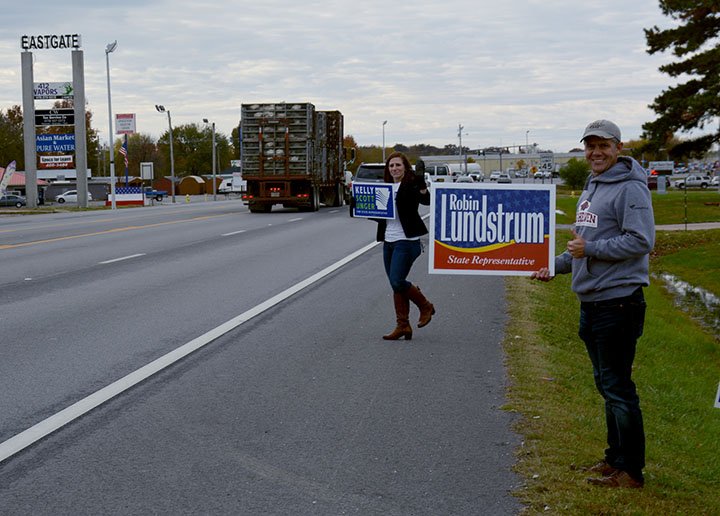 Hunter McFerrin/Herald-Leader In the final stretch of the 2018 midterm elections, both sides of the District 87 election took to the roadway in front of St. Mary Catholic Church -- which was also an Election Day polling place -- on Tuesday morning to try and attract last minute attention from voters. Pictured (from left) Democratic candidate Kelley Scott Unger and Arthur Hulbert, a friend of the current state representative, Robin Lundstrum (R). Election results were not available at press time. For more information, please see the Wednesday edition of the Northwest Arkansas Democrat-Gazette.